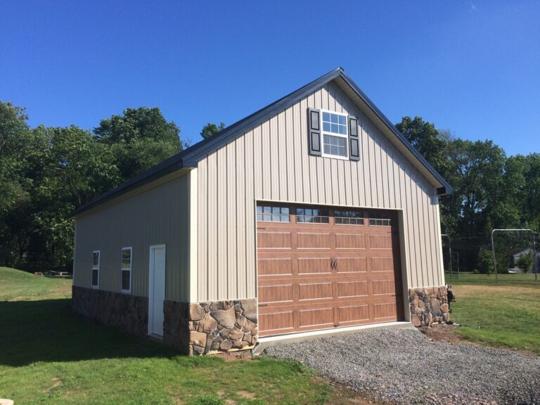 tan 16x60 pole barn garage with stone detailing and reddish brown garage door