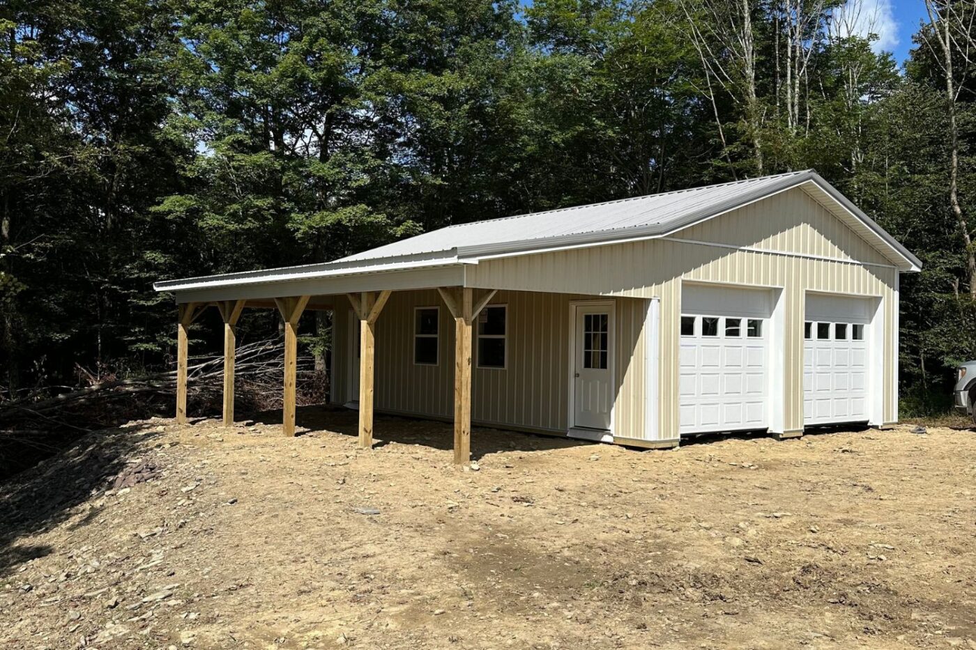 24x32 Pole Barn in Rome PA against trees, white/beige with overhang