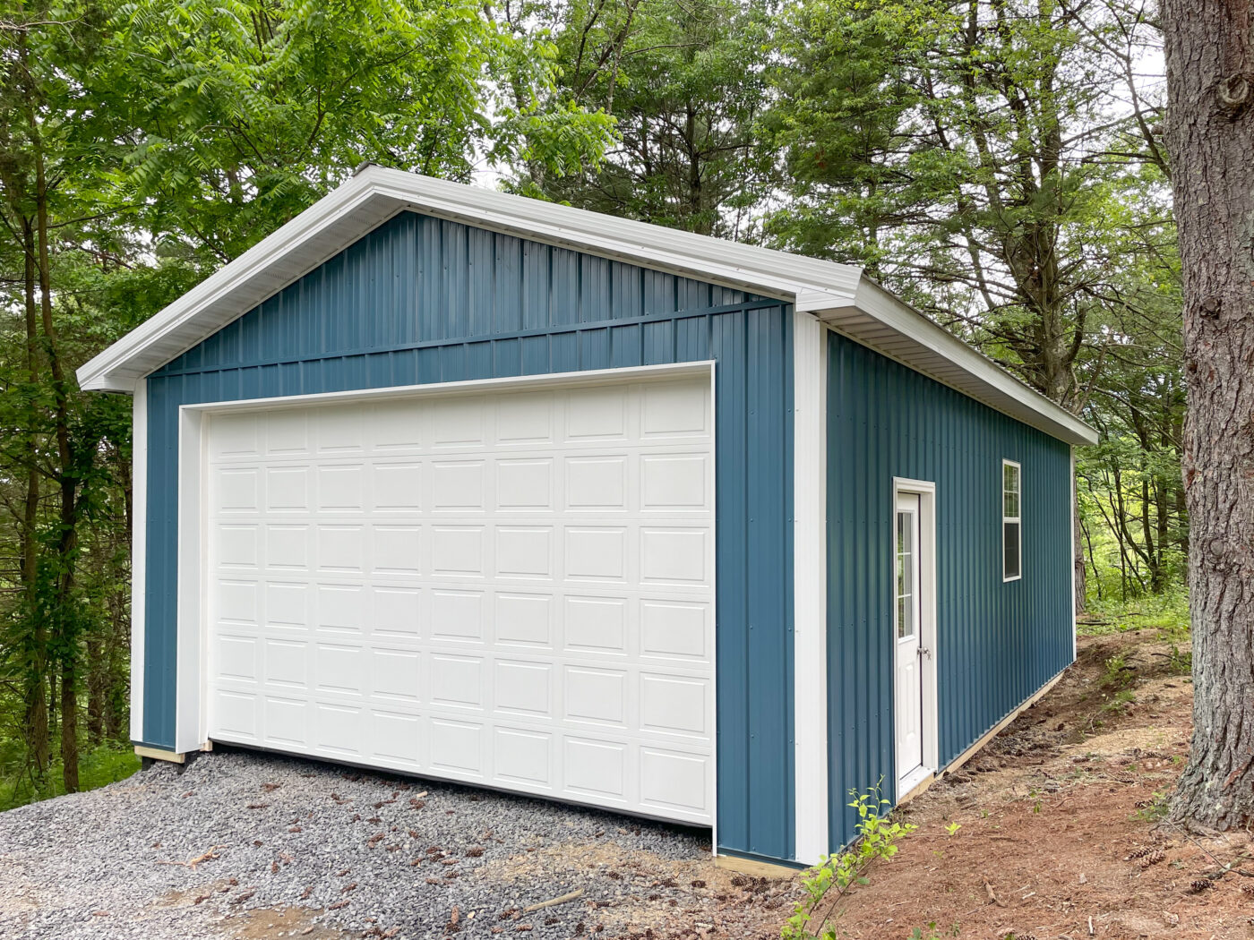 blue one car pole barn garage in Saylorsburg PA with white garage door